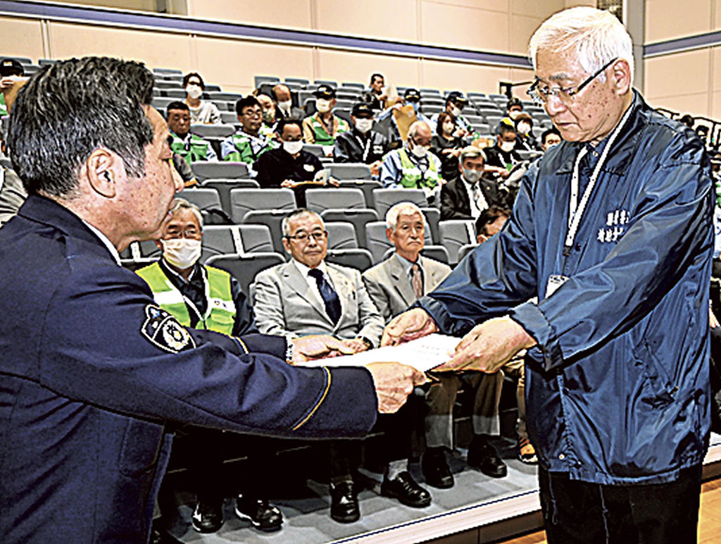 坂田署長（左）から委嘱状を受け取る地域安全推進員＝藤枝市生涯学習センター